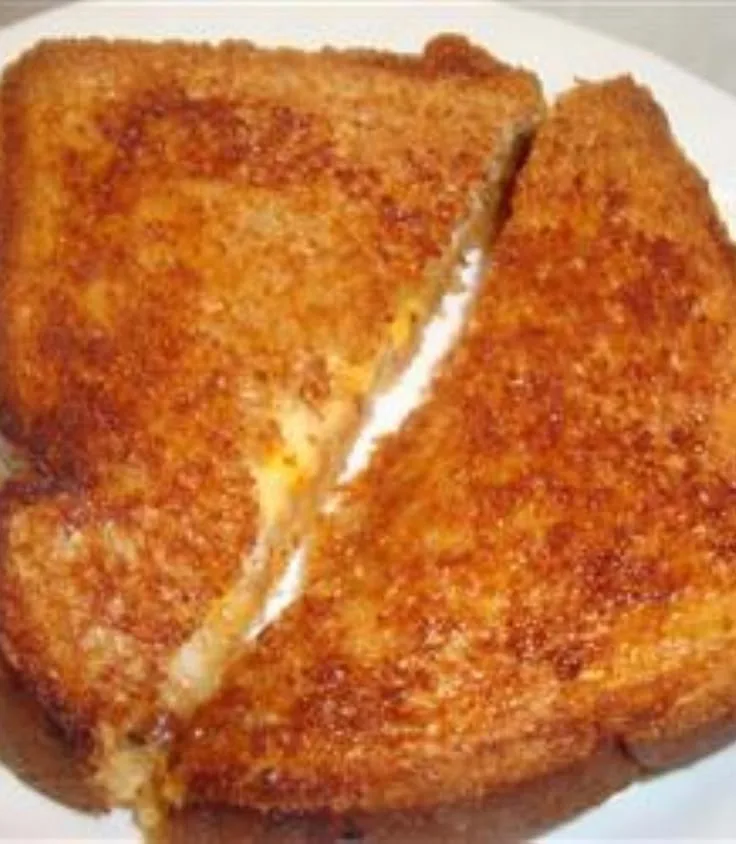 golden brown grilled cheese sandwich on ceramic pan